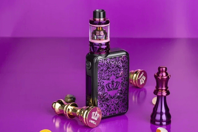 Australian vaper holding banana papaya gunnpod while commuting on a sunny train platform